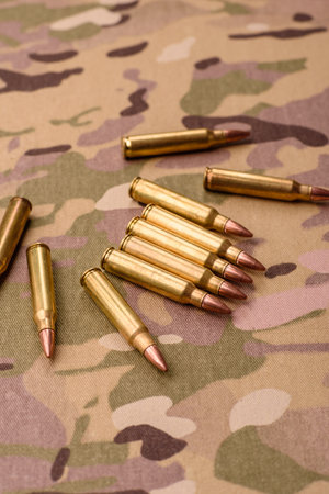 Machine gun cartridges on a camouflage background. Camouflage background as a backdrop for your...