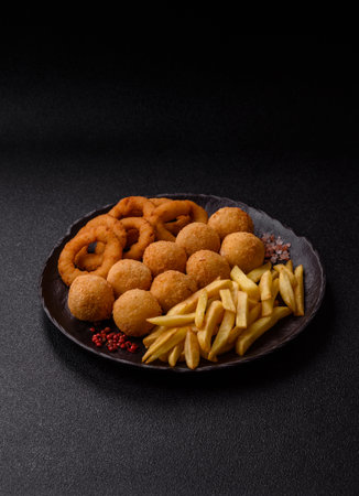 Fast food, cheese balls, onion or squid rings and French fries. Junk food as a background for your designの写真素材