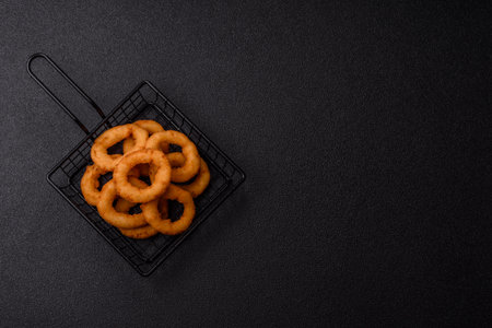 Onion rings or fried squid in breadcrumbs with sauce, takeaway food. Onion rings fried, fast food as a background for your designの写真素材