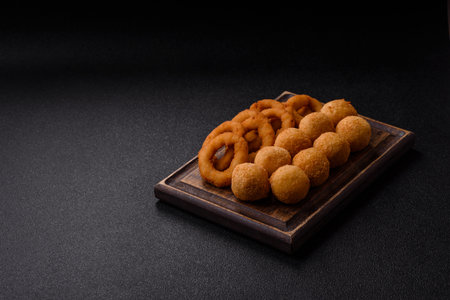 Cheese balls, onion or squid rings and French fries. Junk food as a background for your design