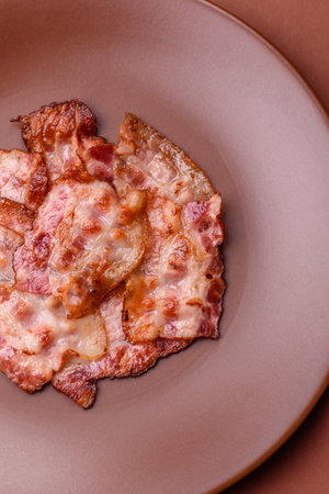 Cooked crispy fried pork bacon strips for a hearty breakfast. Fried bacon strips as a food background for your designの写真素材