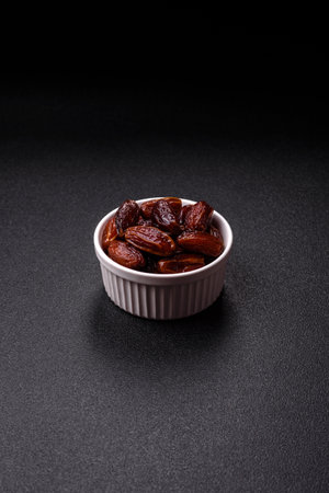 Dried dates in a ceramic plate. Dried dates as a food backdrop for your design.の写真素材