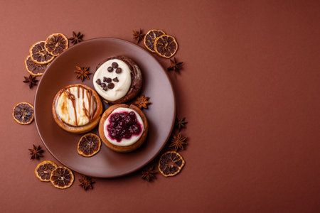 A sweet bun with citrus, cherries, and chocolate, a Danish dessert with cream. Cinnamon roll as a food background for your designの写真素材
