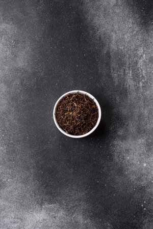 Golden black tea, dried leaves of a Chinese or Indian breakfast drink. Black tea dried leaves as a food backdrop for your designの写真素材