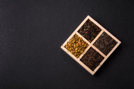 A wooden box with several types of dried tea, green, black, fruit, and chamomile. Dry tea in the box as a backdrop for your design.の写真素材