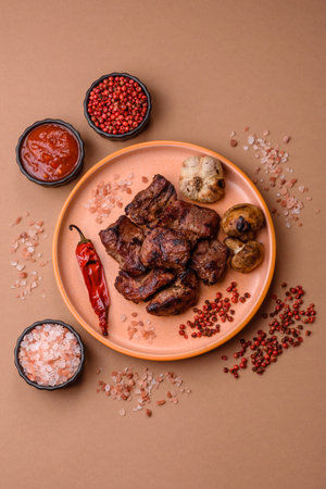 Beef, grilled meat in pieces, or kebab with sauce and vegetables. Beef in pieces as a food background for your designの写真素材