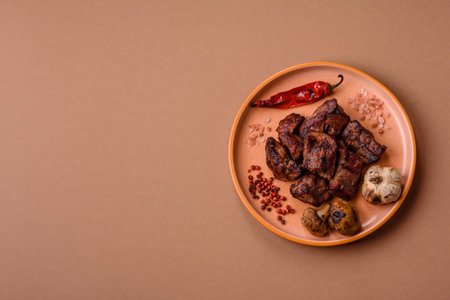 Beef, grilled meat in pieces, or kebab with sauce and vegetables. Beef in pieces as a food background for your designの写真素材