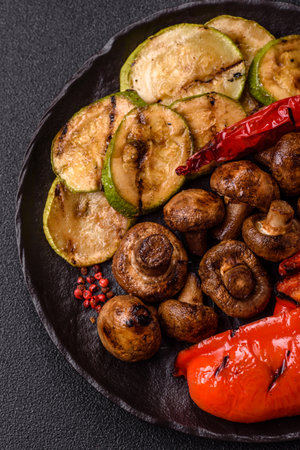 Grilled vegetables, bell peppers, mushrooms, and zucchini, a vegetarian healthy meal with sauce. Grilled vegetables on a plate as a food background for your design.の写真素材