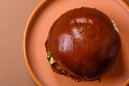 A burger, a hamburger with cheese, beef, and a bun, is takeaway food. A burger or cheeseburger as a food background for your design.の写真素材