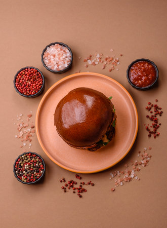 A burger, a hamburger with cheese, beef, and a bun, is takeaway food. A burger or cheeseburger as a food background for your design.の写真素材