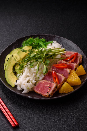 Seared tuna in a bowl with sesame seeds, rice, and vegetables.の写真素材