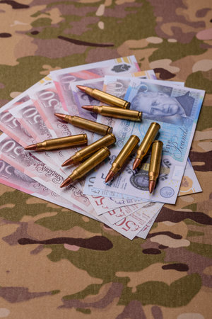 Machine gun cartridges on a camouflage background. Camouflage background as a backdrop for your designの写真素材
