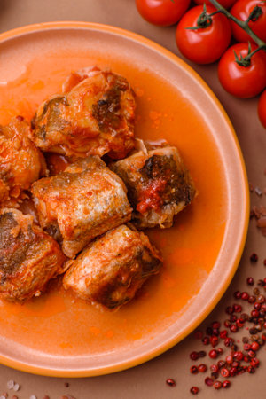 Hake fish cooked in pieces in tomato sauce, stew with peppers and carrots. Hake fish in tomato sauce as a food background for your design.の写真素材