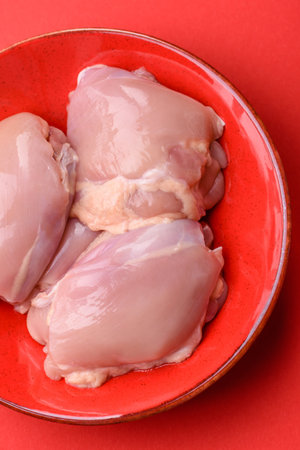 Chicken thigh fillet, skinless and boneless meat for grilling or barbecue. Chicken thigh fillet as a food background for your designの写真素材