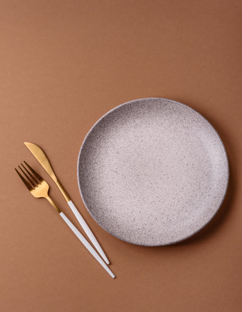An empty round ceramic plate on a table, kitchenware. An empty plate as a food background for your designの写真素材