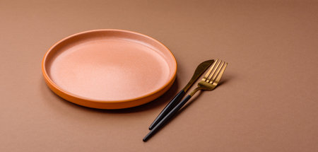 An empty round ceramic plate on a table, kitchenware. An empty plate as a background for your designの写真素材