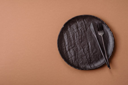 An empty round ceramic plate on a table, kitchenware. An empty plate as a food background for your designの写真素材