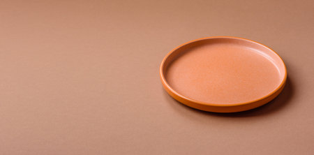 An empty round ceramic plate on a table, kitchenware. An empty plate as a food background for your designの写真素材