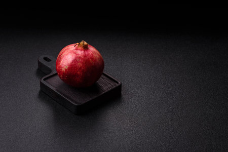 A juicy, ripe, whole red pomegranate as a source of beneficial nutrients. A whole red pomegranate as a food background for your design.の写真素材