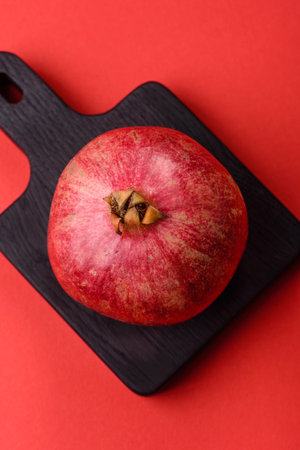 A juicy, ripe, whole red pomegranate as a source of beneficial nutrients. A whole red pomegranate as...