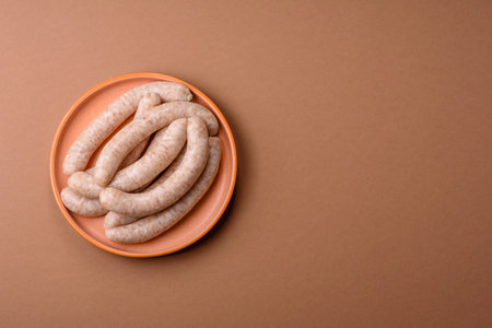 Raw pork or chicken meat sausages for grilling, a spicy picnic food. Raw sausages as a food background for your design.の写真素材