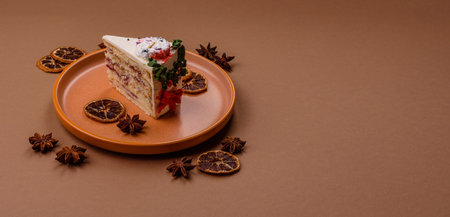 A slice of sweet layered cake with a Christmas ornament and fruit flavor. A slice of cake as a food background for your designの写真素材