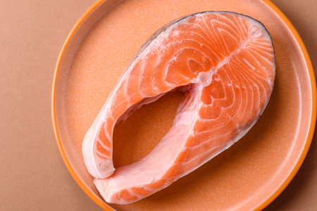 Fish, raw salmon steak, fresh seafood for grilling with salt, spices, and herbs. Raw salmon steak as...