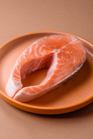 Raw salmon steak, fresh seafood for grilling with salt, spices, and herbs. Raw salmon steak as a...