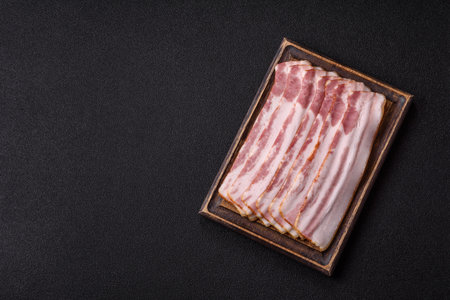 Raw smoked bacon slices, ham, jamon, or prosciutto strips for cooking. Raw bacon slices as a food...
