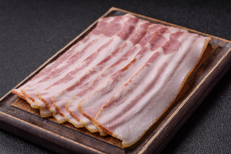 Raw smoked bacon slices, ham, jamon, or prosciutto strips for cooking. Raw bacon slices as a food...