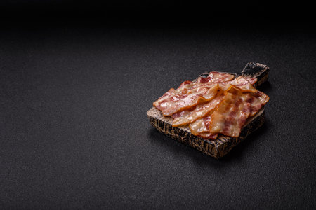 Fried smoked bacon slices, ham, jamon, or prosciutto strips for cooking. Fried bacon slices as a food background for your designの写真素材