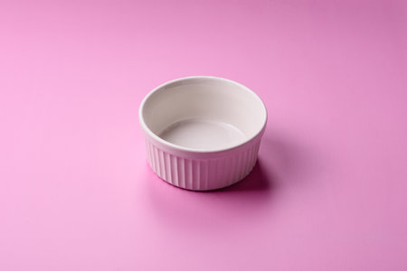 An empty round ceramic plate on a pink background as a kitchen utensil.の写真素材