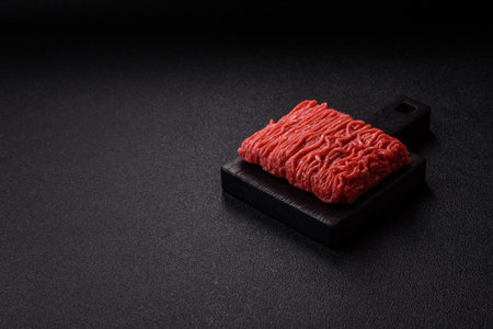 Raw ground beef or pork for burgers or meatballs with salt and spices. Raw ground beef as a food background for your designの写真素材