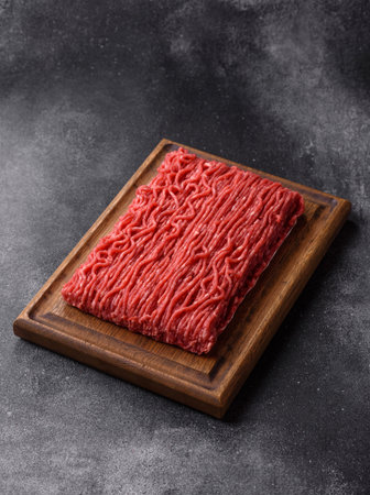 Raw ground beef or pork for burgers or meatballs with salt and spices. Raw ground beef as a food background for your designの写真素材