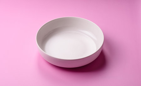 An empty round ceramic plate on a pink background.の写真素材
