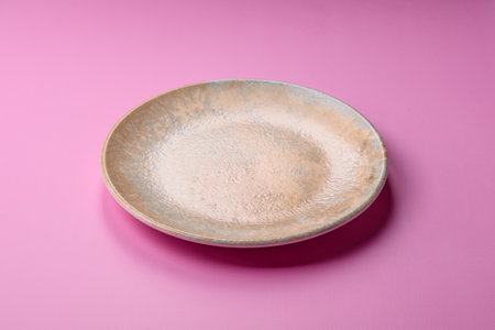 An empty round ceramic plate on a pink background as a kitchen utensil. An empty plate as a food background for your designの写真素材