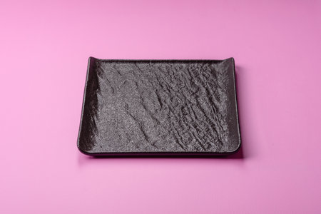 An empty ceramic plate on a pink background as a kitchen utensil. An empty plate as a background for...