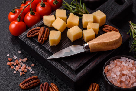 Cubed cheddar, gouda, or parmesan cheese on a cutting board. Cubed cheese as a food background for your designの写真素材