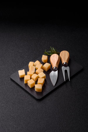 Cubed cheddar, gouda, or parmesan cheese on a cutting board. Cubed cheese as a food background for your designの写真素材