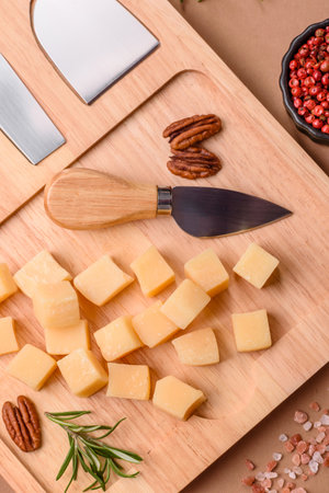 Cubed cheddar, gouda, or parmesan cheese on a cutting board. Cubed cheese as a food background for your designの写真素材