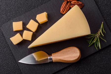 A wedge of cheddar, gouda, or parmesan cheese on a cutting board. Cheese wedge as a food background for your designの写真素材
