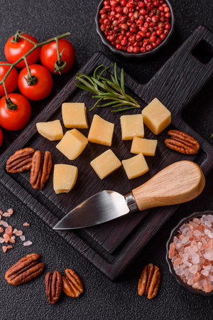 Cubed cheddar, gouda, or parmesan cheese on a cutting board. Cubed cheese as a food background for your designの写真素材