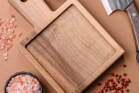 Empty wooden cutting board with a knife, salt, and spices for food preparation. An empty wooden cutting board as a food background for your designの写真素材