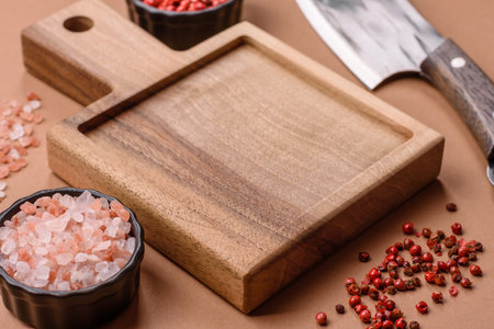 Empty wooden cutting board with a knife, salt, and spices for food preparation. An empty wooden cutting board as a food background for your designの写真素材