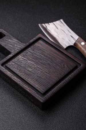 Empty wooden cutting board with a knife, salt, and spices for food preparation. An empty wooden cutting board as a food background for your designの写真素材