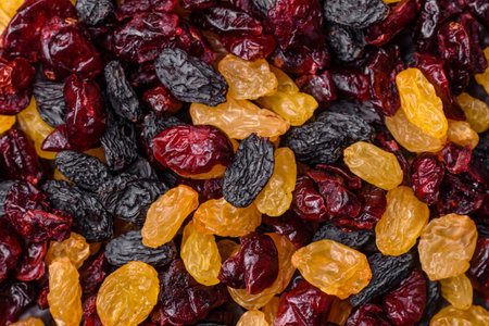 Dried cranberries, yellow and black sweet raisins as ingredients for granola and breakfast. Raisins and cranberries as a food background for your designの写真素材