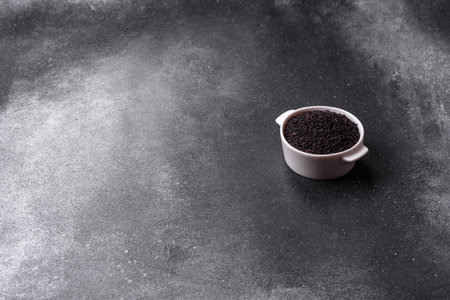 Black sesame seeds in a bowl, an ingredient for oil and healthy eating. Black sesame as a food background for your designの写真素材