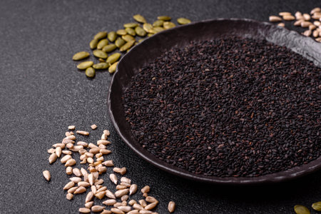Black sesame seeds in a bowl, an ingredient for oil and healthy eating. Black sesame as a food background for your designの写真素材