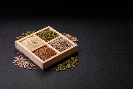 A box of flax, pumpkin, sunflower, and sesame seeds, ingredients for healthy eating. Flax, sesame, pumpkin, and sunflower seeds as a food background for your designの写真素材