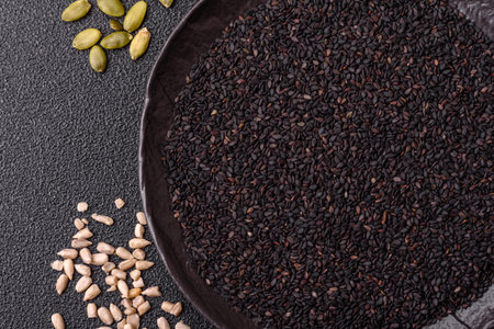 Black sesame seeds in a bowl, an ingredient for oil and healthy eating. Black sesame as a food background for your designの写真素材